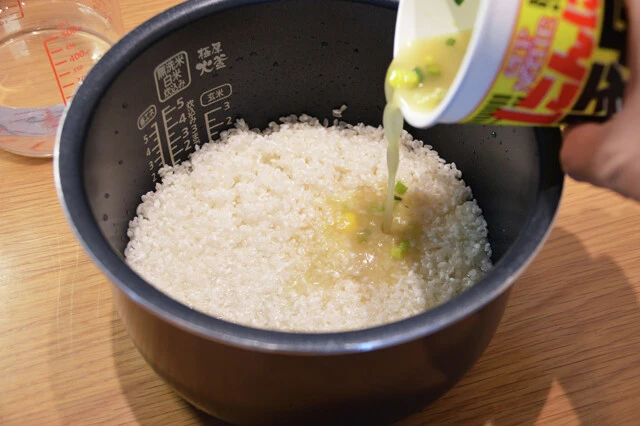 (2)スープ! 米2合をといだらいったんザルに上げ、(1)で用意したスープを入れ、2合の目盛りまで水を追加。今回は(1)を1杯分用意したが、味を濃いめにしたい場合は2~3杯分使用してもよい