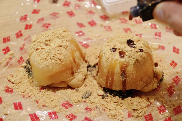 （４）かける！　信玄餅の包装ビニールの上に（３）を取り出し、余ったきなこと黒蜜をたっぷりかけて完成。雪見だいふくの容器に入っているフォークを使って豪快にかぶりつこう。感動のウマさ！