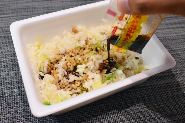 (4)メシ! カレーメシの米とペヤングのかやくはペヤングの容器に移し、熱湯を少しずつ加えながら混ぜると柔らかく戻る。ソースとスパイス、ふりかけを混ぜれば「ペヤンメシ」の完成だ!