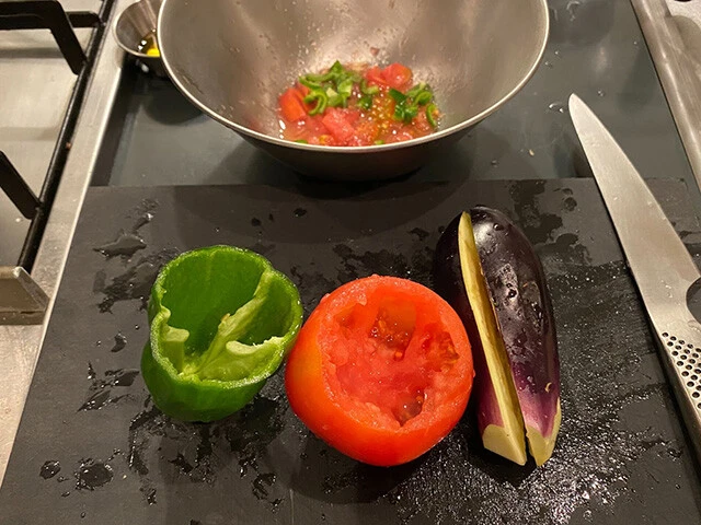 ２．ピーマン、なす、トマトで器を作る（各２個）。ヘタを取り、ピーマンとトマトは中をくり抜き、なすは縦に切れ目を入れる（ヘタの周りやくり抜いた部分はボールに入れ次のタネと混ぜる）