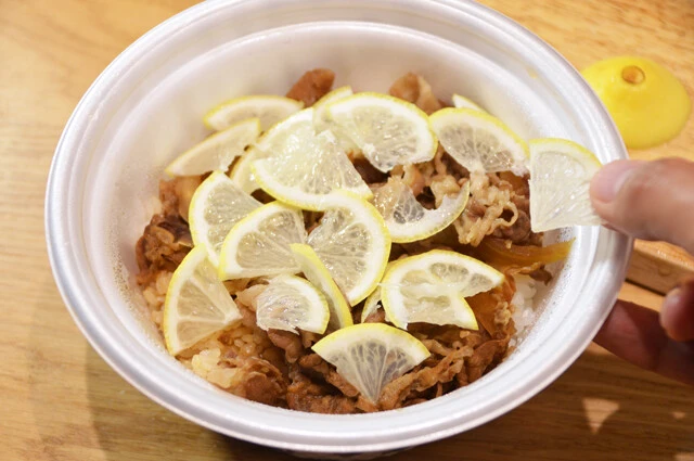 (3)のせる! テイクアウトした牛丼を温めたら、牛肉の上に(2)をまんべんなくのせる。レモンの量はお好みで増減していいが、半個分くらいのせてもいいだろう。牛丼は松屋の牛めしがベスト