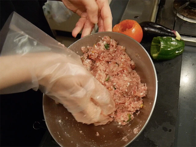 ３．ボールに玉ねぎ半分のみじん切り、挽肉、水を切った米、塩胡椒、すりおろしにんにく、パセリ、クミンパウダー、オリーブオイルを入れ粘り気がでるまで混ぜ合わせる