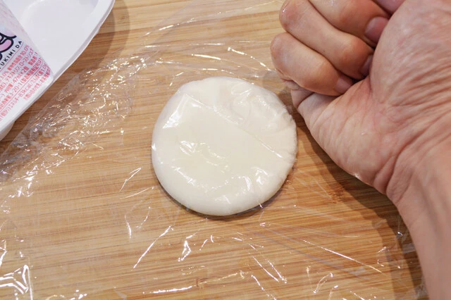 (3)潰す! まな板の上に雪見だいふくをのせ、ラップをかけたら中身のアイスが飛び出さないよう気をつけながら、できる限り薄くのばそう。あとは(2)と(3)を(1)で挟んで食べるだけ!