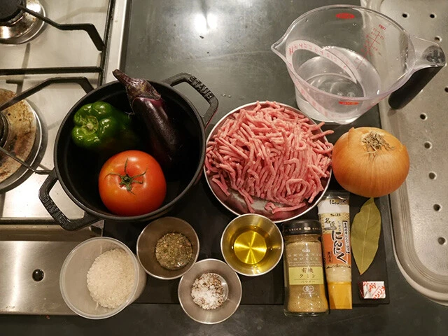 材料：ピーマン、なす、トマト（各２個ずつ）、挽肉、玉ねぎ、水、米、パセリ、塩胡椒、オリーブオイル、クミンパウダー、すりおろしにんにく、ローリエ、コンソメ
