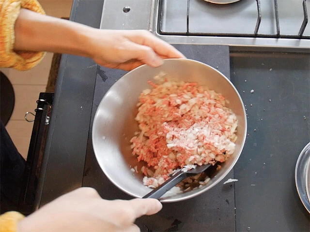 ２．玉ねぎをみじん切りにして挽肉と混ぜ、塩、胡椒、お好きなスパイスで味付けをする。水（分量外）を足しゆるめのタネにすると現地のものに近くなります。