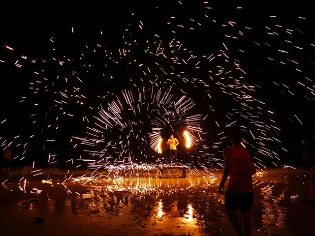 ビーチでファイアーポイ（火の玉をペアで回す道具）