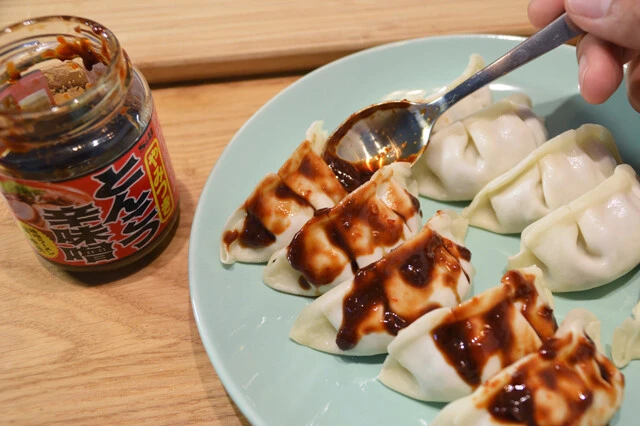 (1)辛味噌! 日高屋の冷凍餃子を袋から取り出し、とんこつ辛味噌を皮にたっぷり塗る。量が多いとだいぶ辛口になるが、チーズとパイ生地のまろやかさで中和されるのでガッツリ塗ろう