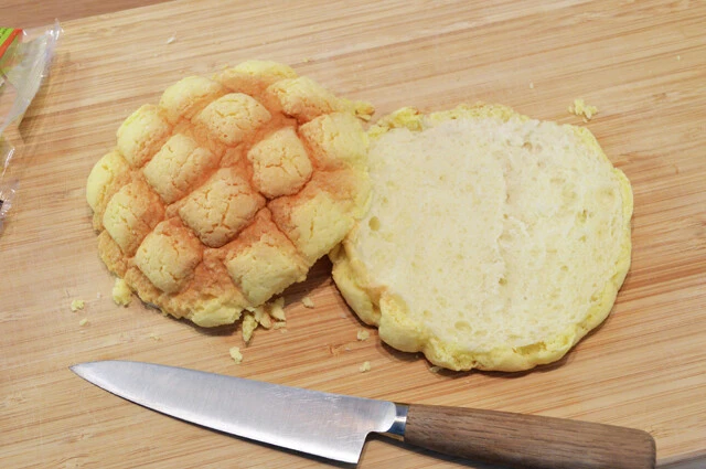 (1)切る! メロンパンを横から半分に切る。メロンパンは商品によって味と食感がだいぶ変わるので、同じ味を再現したい場合は「ファミマ・ザ・メロンパン」を使うのがオススメ