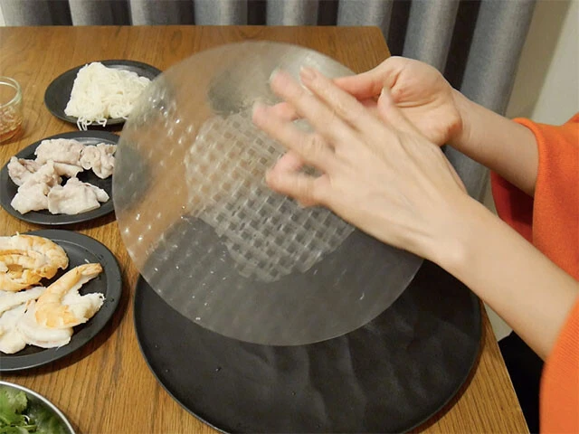 ２．常温水（分量外）を入れたボウルを用意し、乾燥したライスペーパーをサッと濡らし、足りないところは手で撫でるようにして全体を濡らす。