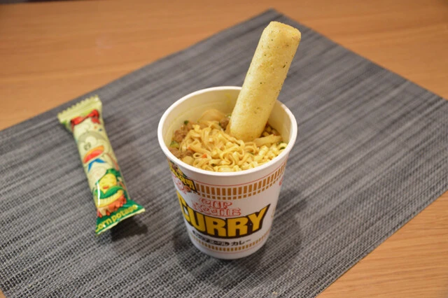 （５）うまい棒カレーヌードル　カレーヌードルにうまい棒を突き立て、溶かしながら食べるのも簡単でウマい。うまい棒はコンポタ味かチーズ味を推奨