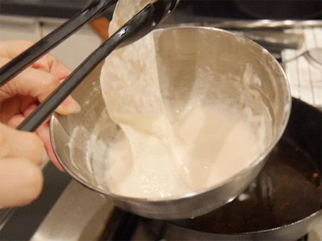 ４．ボウルに衣の材料を入れて混ぜ、タラをくぐらせる。