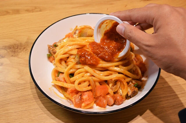 (4)仕上げ! (3)を食器に盛りつけたらスパイシーモスチーズバーガーのミートソースをかけ、粉チーズを振りかけたら完成。ミートソースは店舗によっては別容器で用意してくれるから便利だ