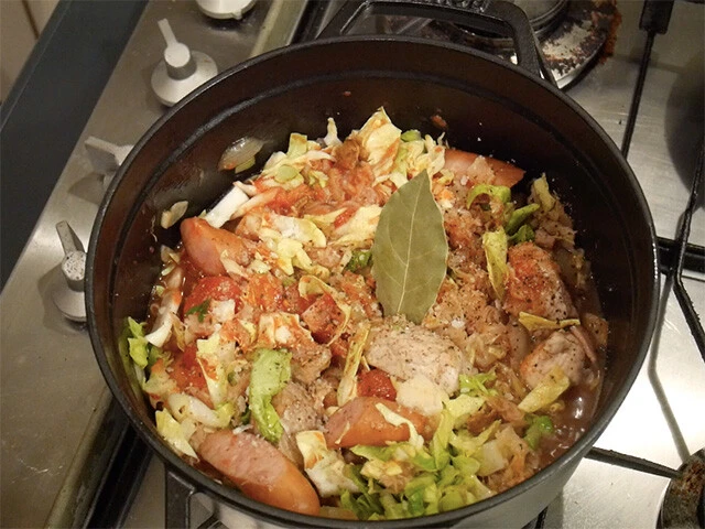 ２．残りの具全て（ザワークラウト、キャベツ、乾燥ポルチーニと戻し汁、プルーン、ワイン、トマト缶、ローリエ）を加え、塩胡椒で味を整え、弱火で１時間以上煮込む。