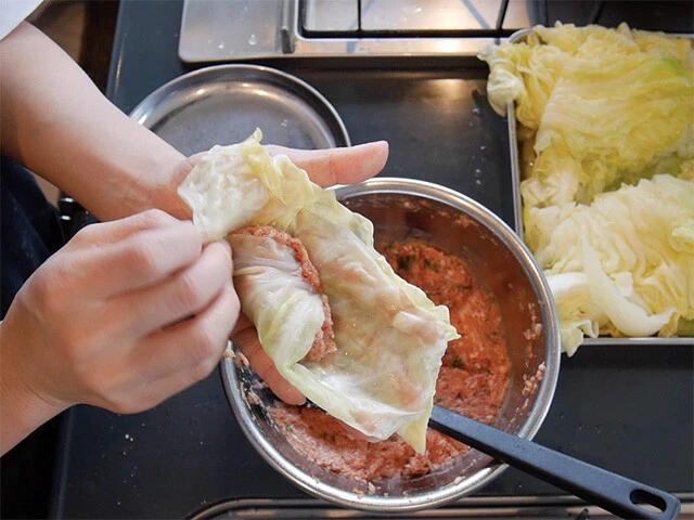 ５．キャベツの葉にタネを乗せて俵型に包む。（包み方は自由。クルクル巻いて端を押し込んだり、プレゼントのように包むなど）