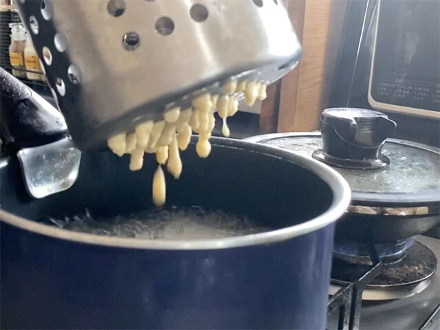 ２．ボウルにすりおろしたジャガイモ、小麦粉、塩、卵を入れ、もったりした状態まで混ぜたらにしたら、沸騰した鍋に生地を少しずつ落とし茹でていく。あればおろし器などの丸穴から押し出し、なければスプーンで少しずつ落とすか、生地をまな板に乗せ包丁で削ぎ落としていく。（生地が湯の中で溶けてしまうなら柔らかすぎなので粉を加えて調節します）