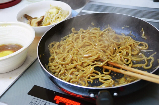 (1)焼く! 豚ラーメンをレンチンしたら麺だけをフライパンに移し、スープを半量ほど入れて焼く。スープの水分がすべて飛んだら火を止めよう。軽く焦げ目をつけると食感が激ウマに!