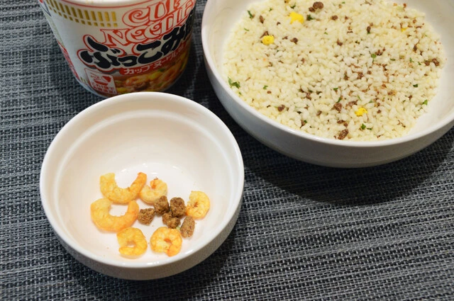 (1)救出! 餃子の中身となる具材を増やすため、カップヌードル ぶっこみ飯を開けて謎肉とエビを救出する。余ったぶっこみ飯は熱湯を入れて仕上げ、餃子ライスにして食べるしかない!