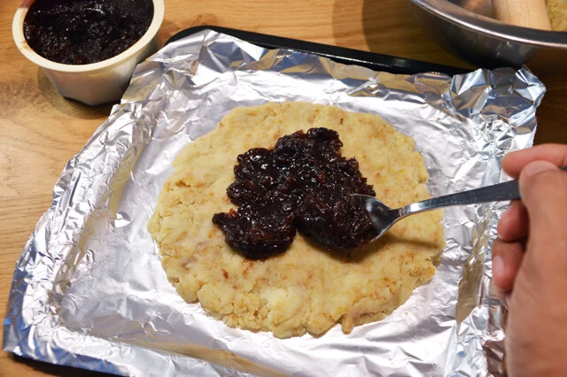 (2)あんこ! アルミホイルなどの上に①を薄く延ばしたら中央にあんこをたっぷりのせ、さらに(1)をかぶせて顔を作る。表面がボコボコしている場合は薄く水を塗って延ばし、ならすとよい