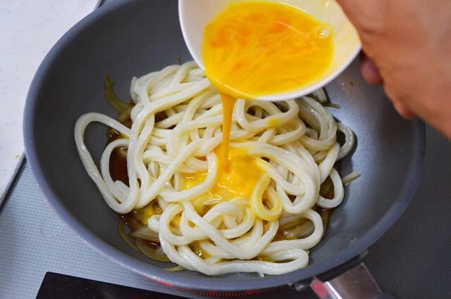 (3)卵とじ! (2)の上からうどんを入れ、卵を加えてさらに加熱。卵が固まってきたら火を止め、ご飯の上からかける。使う麺の量は半分程度でも十分。おなかのすき具合に合わせて調整しよう