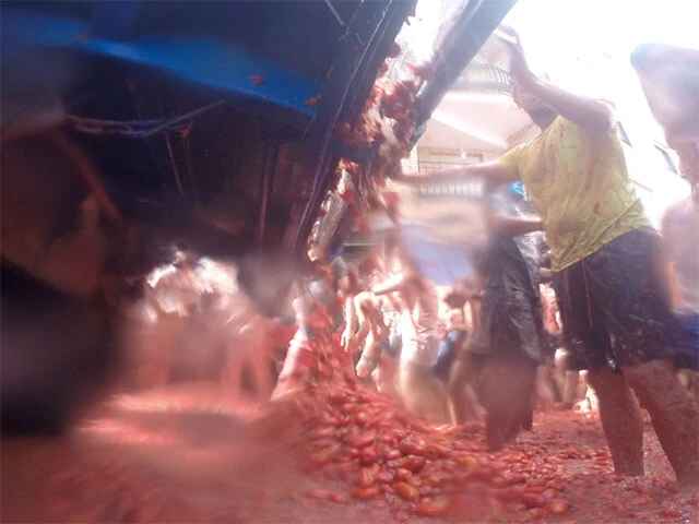 トラックの荷台から流れ落ちる大量のトマト