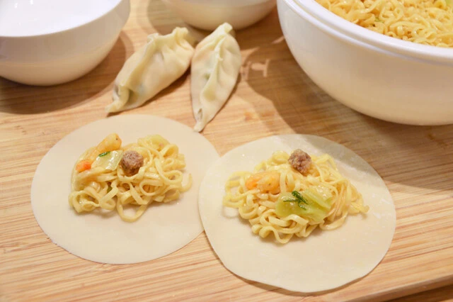 (3)包む! 餃子の皮をまな板などの上に並べ、麺と具材を中央に置いて包もう。麺は1個当たり2、3本で十分。包む寸前にスープをスプーンなどですくい、中に少量垂らすとおいしさUP!