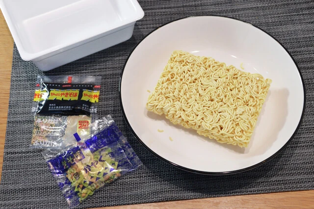 （１）取り出す！　ペヤングを開封し、中身をすべて取り出したら麺を深さのある食器に移し、カット野菜などお好みの具材を麺にのせる。かやくと液体ソースは開けたらそのままカップに入れよう