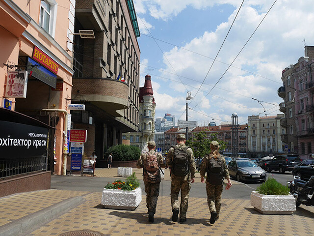 首都キエフの街中を歩く迷彩服の男女