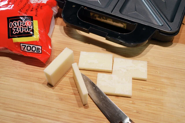 (1)切る! 餅を包丁で半分の厚さに切る。使用するホットサンドメーカーが三角形タイプの場合はさらに細かく切り、パズルのように形を合わせていく。餅は溶けるので、だいたいでOKだ