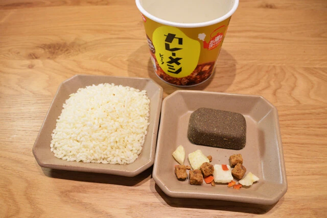 (1)分ける! 日清カレーメシを開封し、中から米、カレールウ、具を取り出し、素材ごとに分ける。具は細かいものもあるので注意。その後、カレールウと具をカレーメシのカップに戻そう