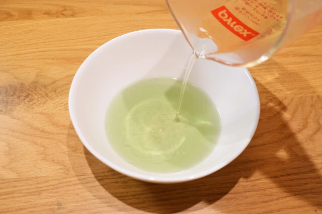 (2)ゼラチン! (1)が溶けたらまず緑のほうに溶かしたゼラチンを加えてよくかき混ぜる。半球形の型に流したら同じ形の型を重ねた状態で冷蔵庫に入れて固める。ゼラチンの量はケチらないこと!