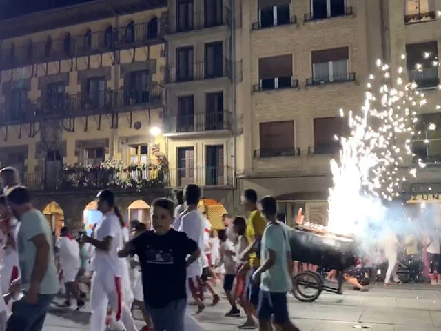 火花を散らす模型の牛から逃げる子供たちと親