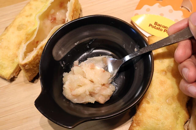 (1)取り出す! ベーコンポテトパイの側面を包丁で切り落とし、スプーンを使って中身のソースを取り出す。適当に開いても問題はないが、丁寧に開くと手順(5)のカスタムがしやすくなる