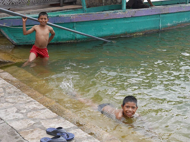 湖で泳ぐグアテマラの少年たちの笑顔