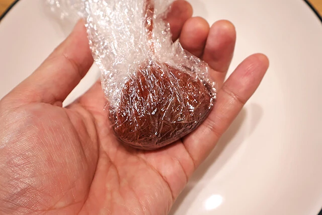 (2)固める! (1)が少し冷めたら表面に薄くサラダ油を塗ったラップに移し、お好みの大きさに丸めて冷蔵庫に入れて固まるまで冷やす。写真は男梅グミ2袋全量を使った特大サイズだ