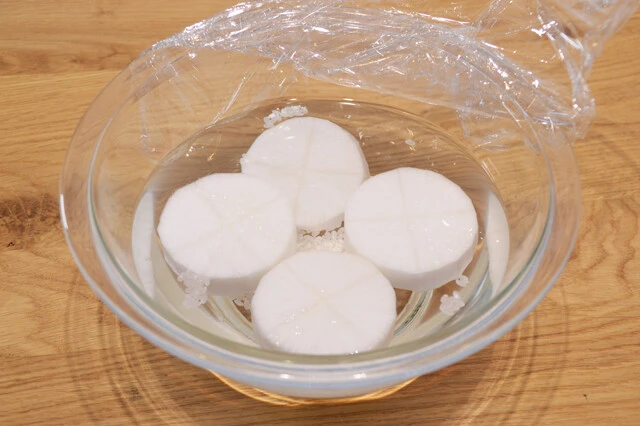 (1)下ゆで! 大根は下ゆでが肝心。皮をむいたら2㎝ほどの厚さに切り、片面に十文字の切り込みを入れ耐熱容器に移す。米大さじ1を入れ、水をかぶるくらいに注ぎ600Wで6分レンチンしよう