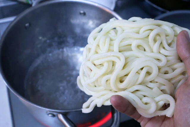 (2)ゆでる! 鍋にたっぷりお湯を沸かし、スーパーで売っているゆでうどんをゆでる。冷凍うどんでも代用できるがコシが強いとソースとの一体感が出にくいので、その場合は長めにゆでよう