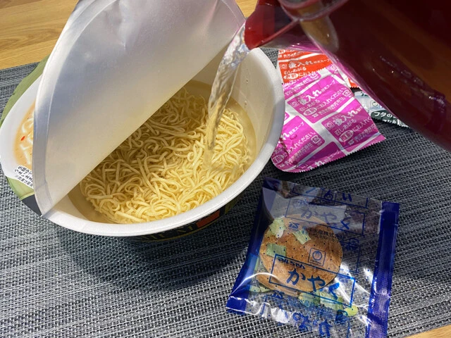 (1)熱湯! 「麺屋極鶏 鶏だく プレミアム」のフタに包丁などで湯切り用の穴を開け、かやくや粉末スープを入れずに熱湯を注いで5分待つ。穴はあまり大きく開けると麺が出ちゃうので注意