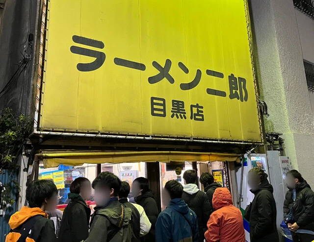 ラーメン二郎の神田神保町店と目黒店。どちらも根強いファンを持つ。店の前には常に行列ができ、着席まで1時間以上待つことも多い。目黒店はいまだに500円ワンコインでラーメンを食べられる高コスパ店として若者の支持を集めている