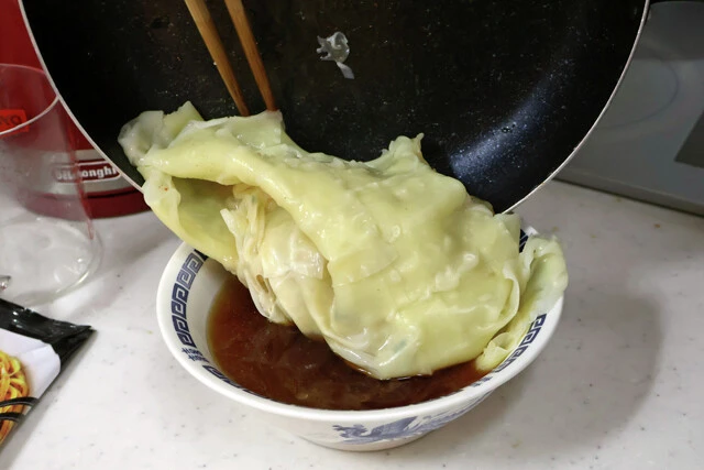 (3)仕上げ! あらかじめラーメンのスープを作り、(2)がゆで上がったらフライパンを傾けてお湯を捨て、ワンタンを滑らせるように丼に入れる。仕上げにネギなどのお好みの具を入れたら完成