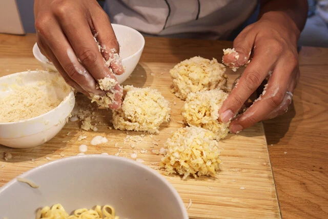 （２）丸める！　麺の水気をしっかり切ったら両手で麺を「たまきん」程度の大きさに丸めて揚げる準備を進める。熱いのでやけどには注意。小麦粉をまぶし、溶き卵を絡めたらパン粉をつけよう