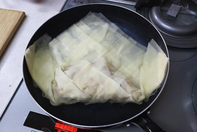 (2)ゆでる! フライパンに(1)を入れたら沸騰させておいたお湯を注ぎ、そのまま加熱してゆでる。ひっくり返すのは難しいので、大きめのフライパンにたっぷりの熱湯を注いでゆでるのがコツ