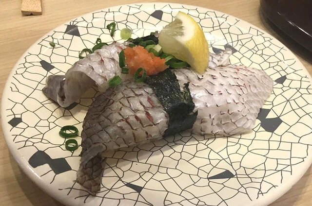 大起水産 回転寿司（大阪）活〆真鯛霜降り／マグロ問屋がルーツの大阪の雄。当然マグロの仕入れは強いが、それ以外もおいしい。このネタは皮の弾力ともみじおろしがアクセント