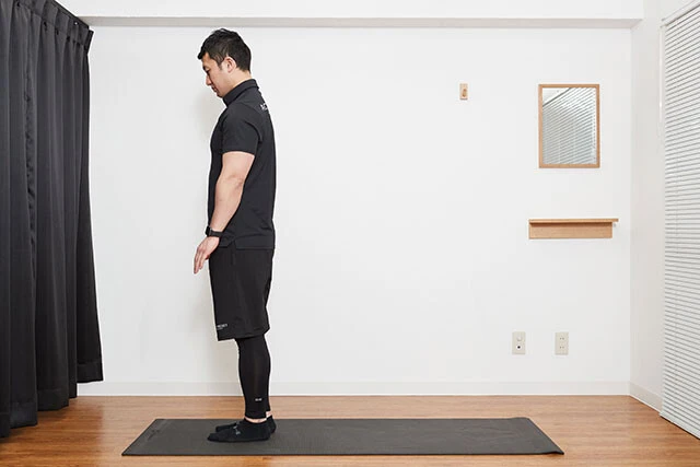 ストレッチ①脚を肩幅に開き、しゃがんで両手を床につく