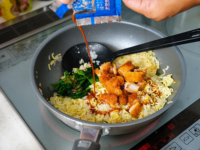 「横浜家系豚骨醤油ラーメン」の麺を粉砕し、少量の水で戻したらフライパンを熱して鶏油を入れ、刻んだファミチキとご飯と卵を炒める。味つけは液体スープ一発でOK!