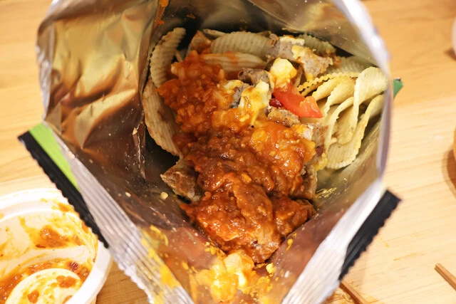 (2)入れる! 湖池屋ストロングの袋を開け、細かくカットした(1)すべてとバーガーのソース、チリディップソースをすべて投入。バンズは使わないが、完成した料理を挟んで食べても激ウマ