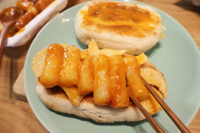 (2)トッポギ! ピザポテトを開封し、チーズがたっぷりと付着しているチップを厳選して(1)の上にのせる。その上にトッポギも並べる。ここの手順をなるべく丁寧にしておくと形が崩れにくい