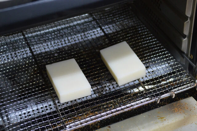 (2)焼く! 具材を煮込む間に餅を焼いておく。餅巾着を作らない場合は焼けたらそのまま(1)に入れればOK。餅巾着にする場合は(3)の手順に進む。膨れてしまった場合は少し形を整えよう