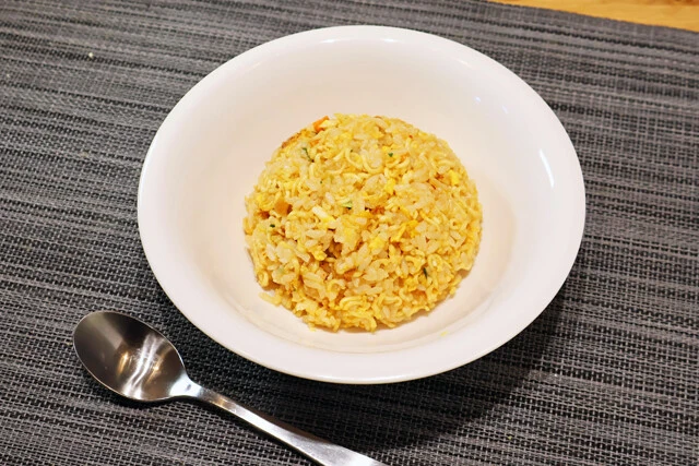 トップバリュ 魚介&キムチの旨辛炒飯 「魚介&キムチの旨み~」をジップロックなどに入れて砕いて水に浸す。鍋でご飯と卵を炒めたらカップ麺を全量投入して炒めるだけ。うまみと辛みが爆発する絶品炒飯の爆誕だ!