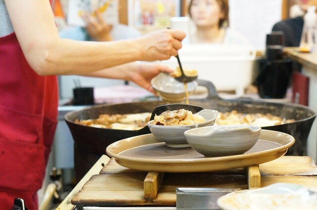 コの字カウンターの中にある大鍋から煮込をよそう