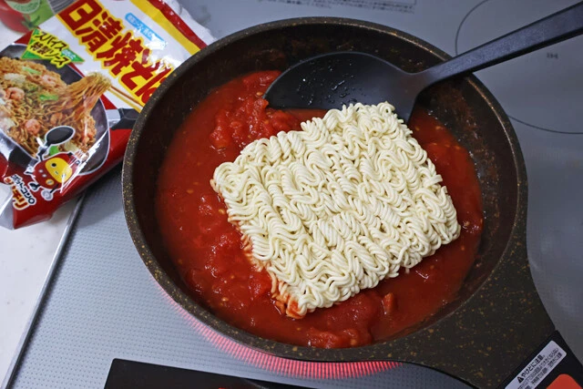 (2)麺! (1)が煮立ったら日清焼そばの麺を投入。水分を吸収させたらひっくり返すのを何度か繰り返し、麺が柔らかくなってきたら少しずつほぐす。焦ってほぐすと麺が切れるので要注意